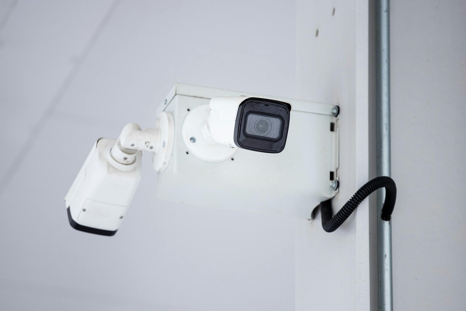 service-1 A close-up shot of a modern, mounted surveillance camera highlighting security and surveillance.