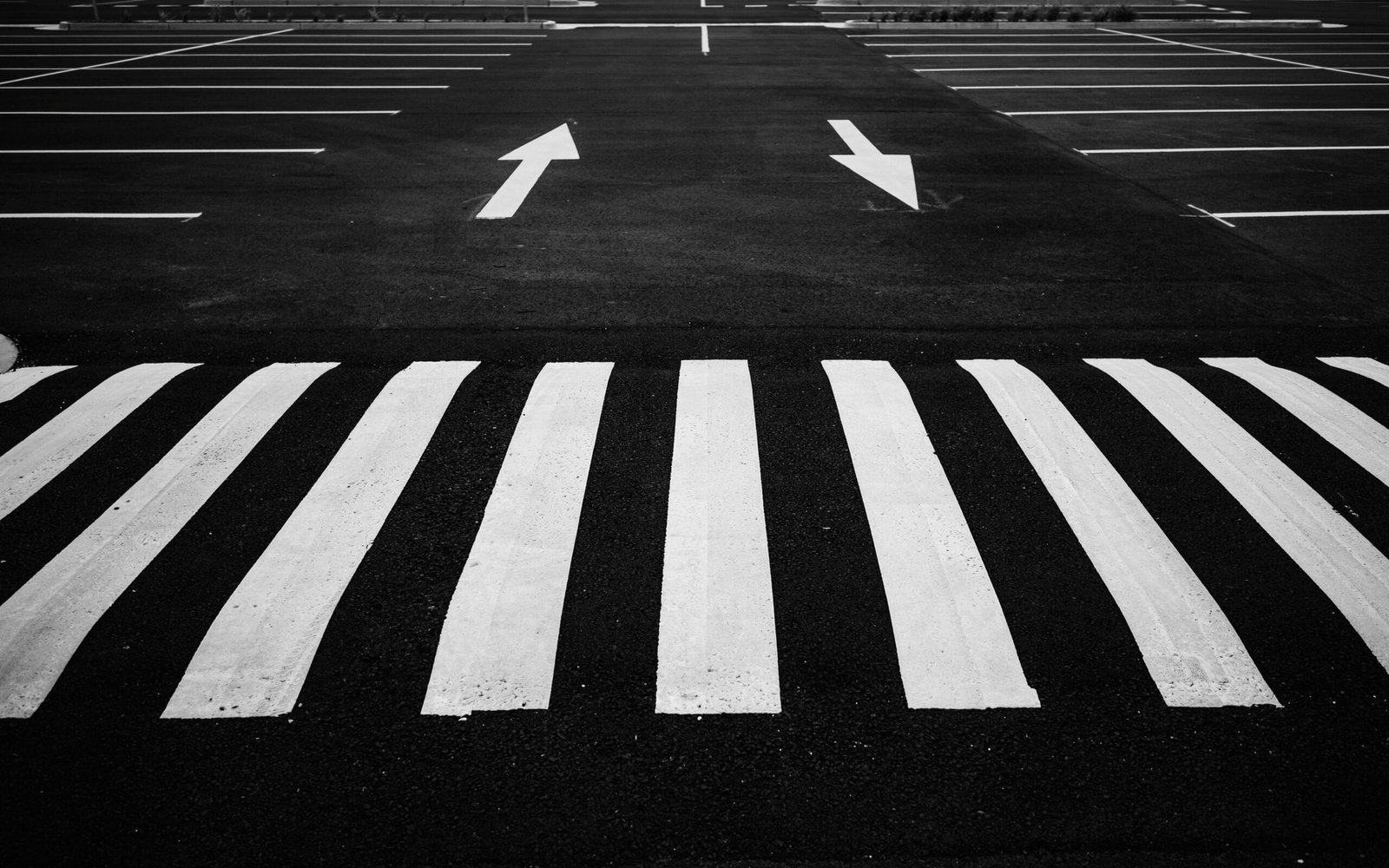 service-1 Black and white image of a parking lot with zebra crossing and directional arrows.